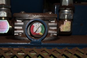 Lors d’un accompagnement d’implantation de processus de maintenance, nous avons été surpris par le nombre de décibels anormalement élevé émis par l’unité hydraulique d’une grosse presse. Nous avons posé la question à l’opérateur et au mécanicien sur place, à savoir, s’ils trouvaient que le son émis par la pompe était normal ? Ils nous ont confirmé que ça l’était. Nous avons demandé au mécanicien quand il avait changé le filtre et remplacer et/ou filtrer l’huile hydraulique pour la dernière fois. Il ne s’en rappelle pas, par contre, il nous précise que les interventions se font lors que le manomètre différentiel commence à entrer dans la zone jaune et que pour le moment l’aiguille était dans le bas de la zone verte. La réalité est toute autre et en voici notre analyse : comme ces deux employés travaillent quotidiennement près de l’unité hydraulique, l’augment du nombre de décibels s’est fait graduellement au cours des mois précédents de sorte qu’ils s’y sont habitués et n’en n’ont pas fait de cas. Si on examine attentivement le manomètre différentiel, on constate que l’aiguille n’est pas dans le bas de la zone verte, mais bien dans le haut de la zone rouge appuyée sur la pin de fin de course ! L’huile n’est plus filtrée et passe par le By-Pass de l’unité de filtration, la crépine d’aspiration de la pompe est bouchée et le bruit perçu est de la cavitation.